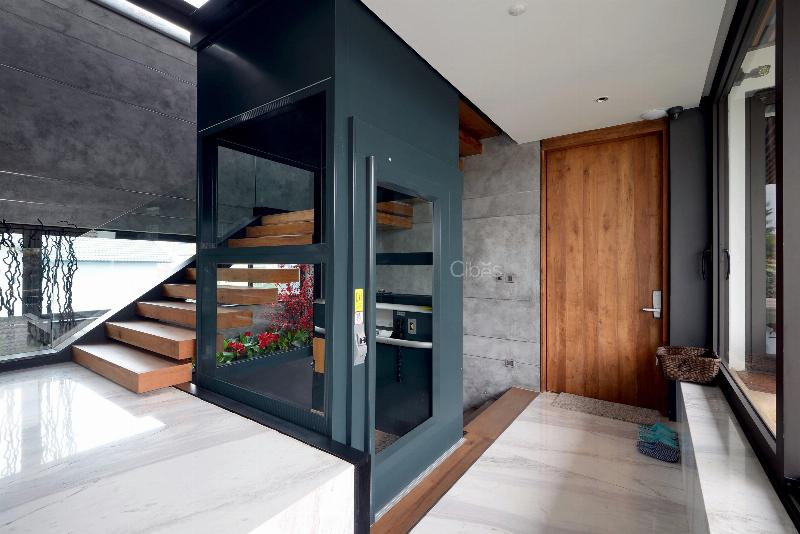 Một người đang xem xét các yếu tố ảnh hưởng đến giá thang máy gia đình như loại thang, tải trọng, tốc độ và thiết kế.