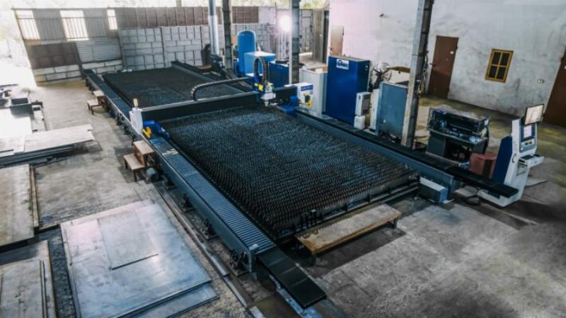Chuyên gia trong ngành gia công kim loại đang tư vấn hoặc thảo luận về các phương pháp tối ưu hóa chi phí cắt CNC sắt tấm.